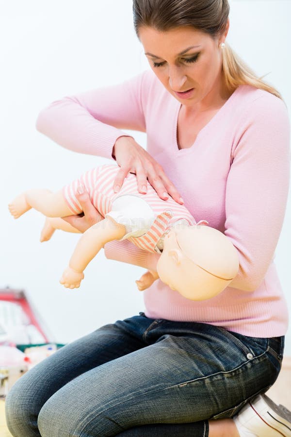 Woman in First Aid Course Practicing Revival of Infant on Baby D Stock