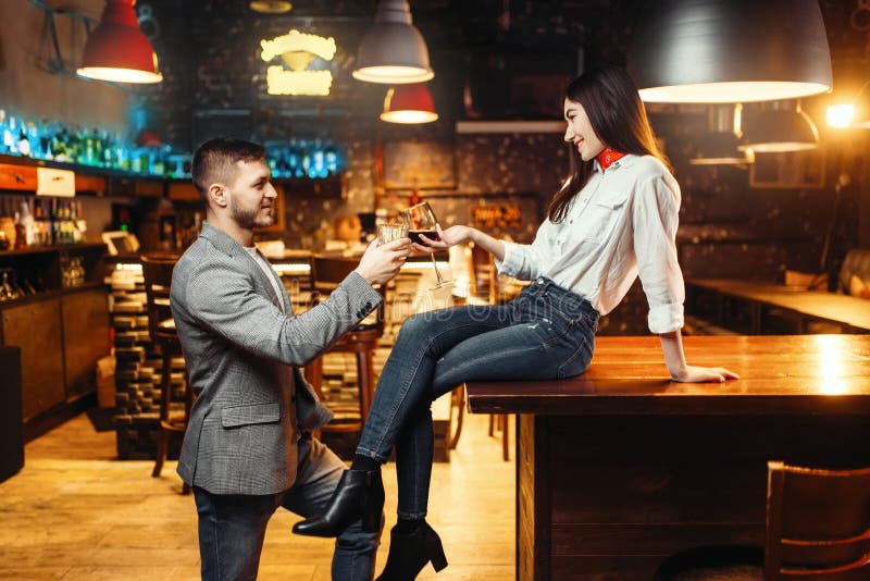 Woman flirting with man, couple at bar counter