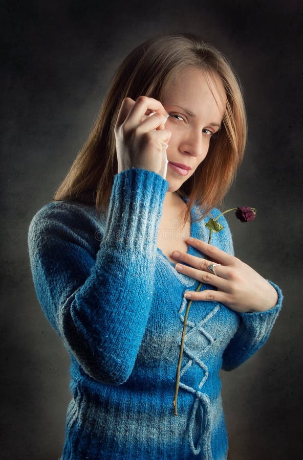 Donna triste holding fiore e asciugandosi gli occhi.