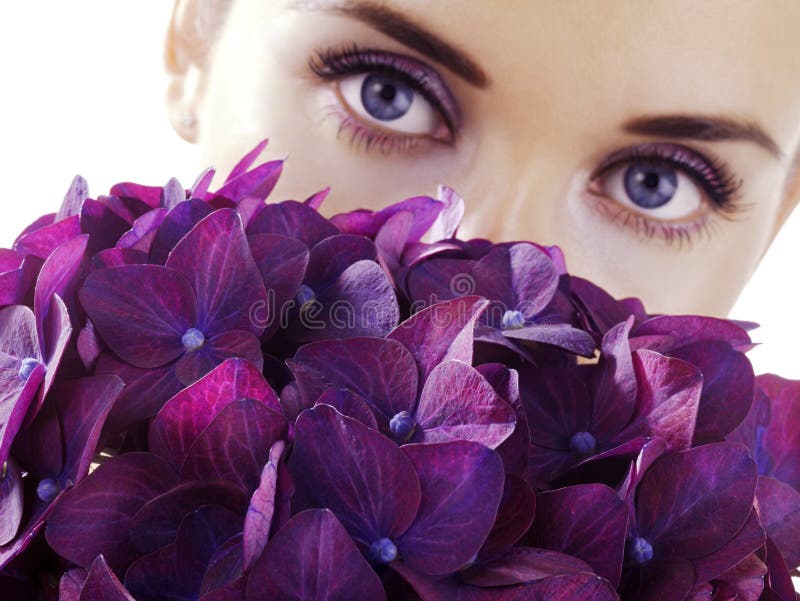 Woman with flowers. Woman with purple flowers. Focus on flowers royalty free stock photography