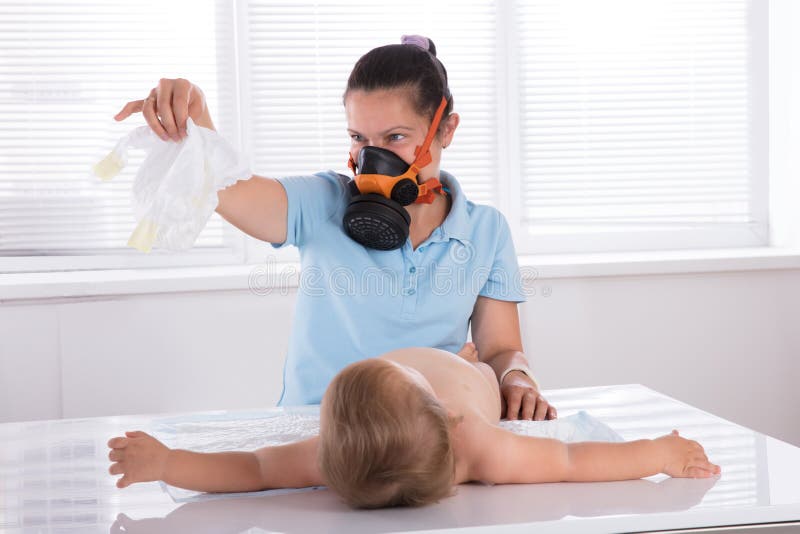 Woman Changing Smelly Nappy Of Her Baby stock photography Woman Changing Smelly Nappy Of Her Baby stock photography