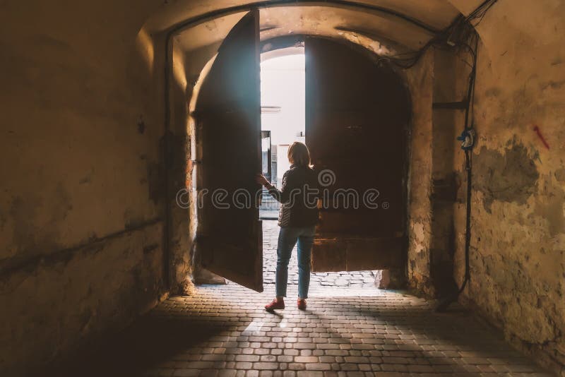 Woman at the Gate in the Archway between the Houses Stock Photo Image