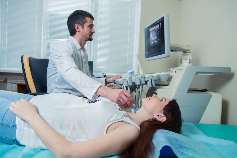 Woman getting ultrasound of a thyroid from doctor royalty free stock photography Woman getting ultrasound of a thyroid from doctor royalty free stock photography