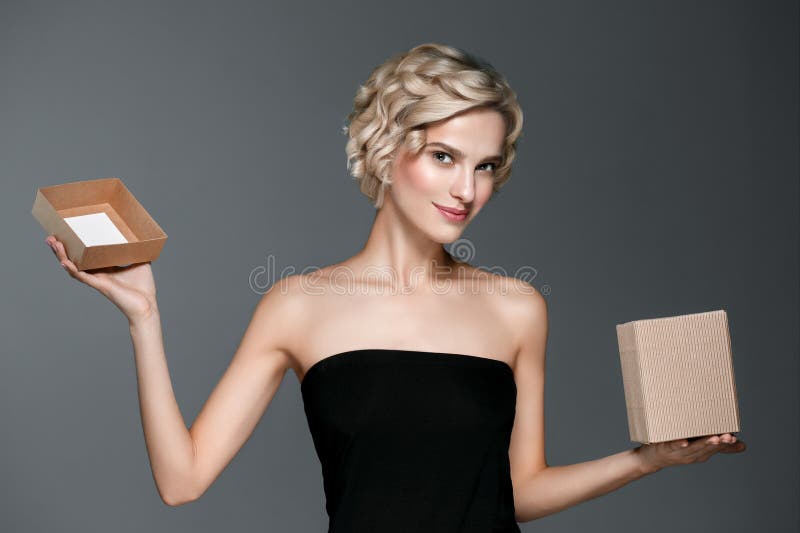Woman with gift box in hands over gray background royalty free stock photos Woman with gift box in hands over gray background royalty free stock photos