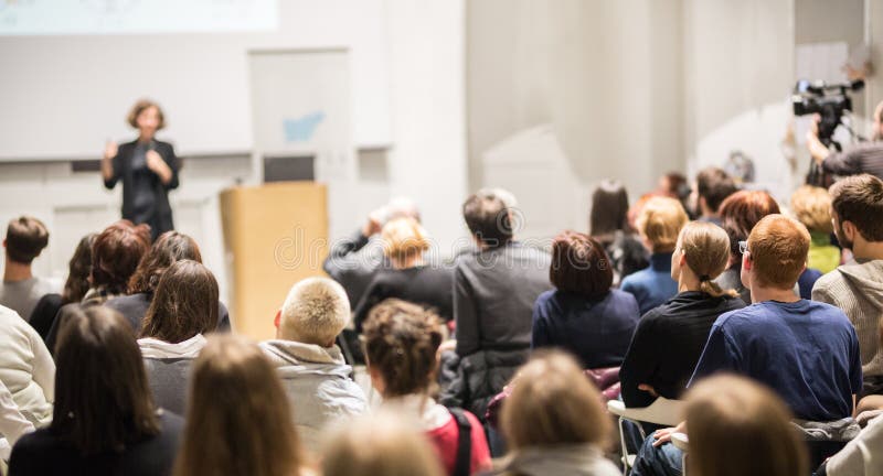 Woman giving presentation in lecture hall at university.