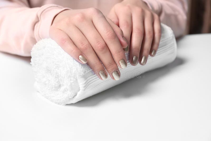 Woman with Gold Manicure on Rolled Towel at Table, Closeup Stock Image