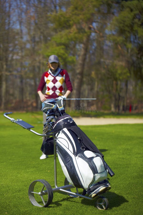 Woman at the golf range with trolley bag