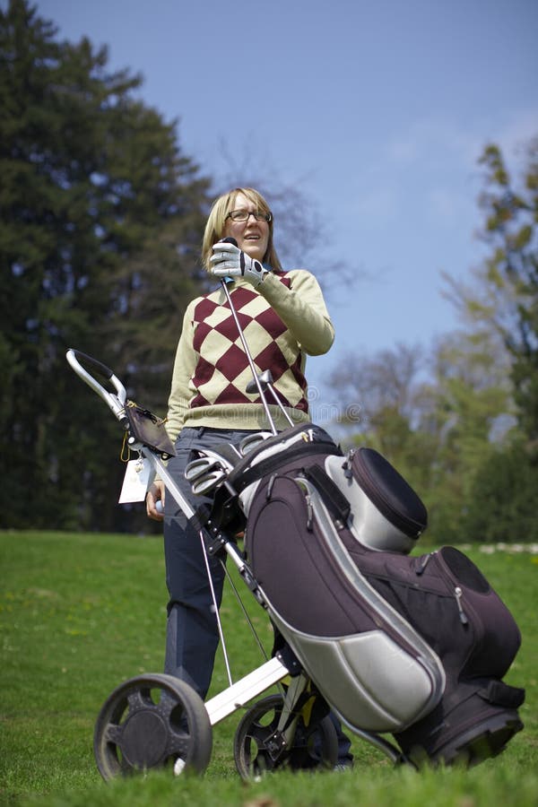 Woman with a golf trolley and clubs