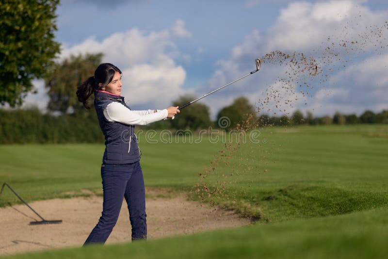Woman golfer playing out of a sand bunker stock photo Woman golfer playing out of a sand bunker stock photo