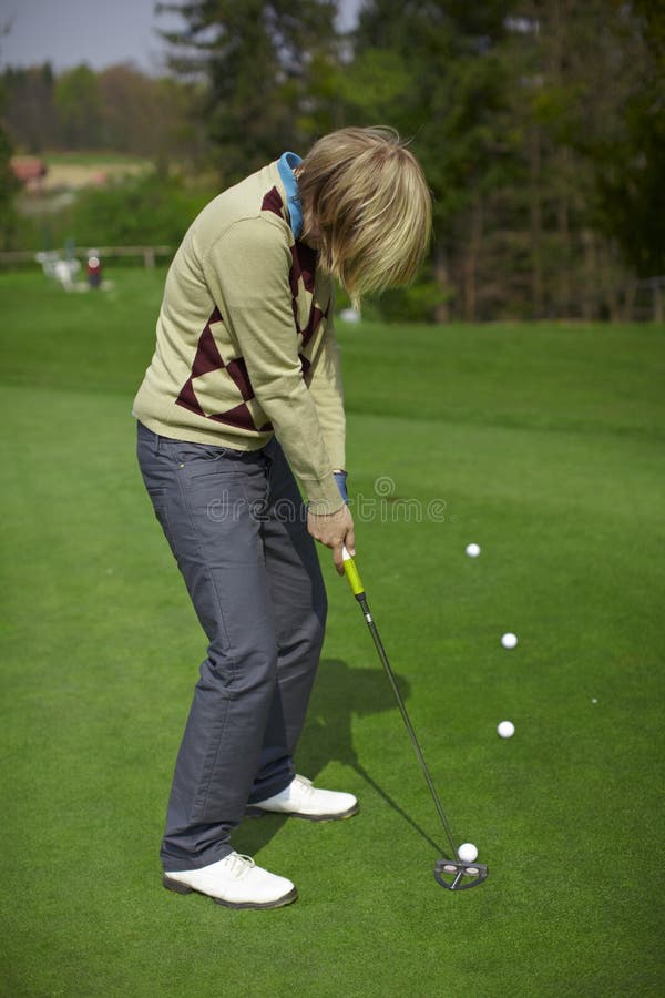 Woman golfer practicing putting