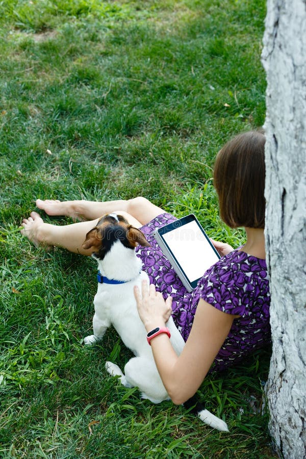 Woman on grass with tablet stock images