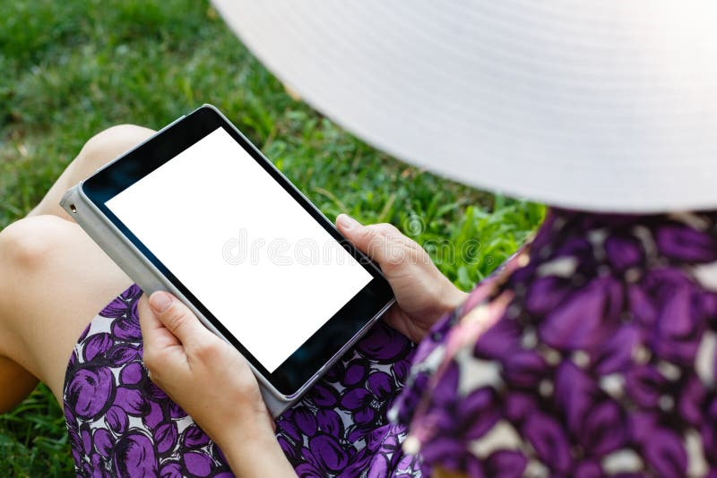 Woman on grass with tablet stock photo