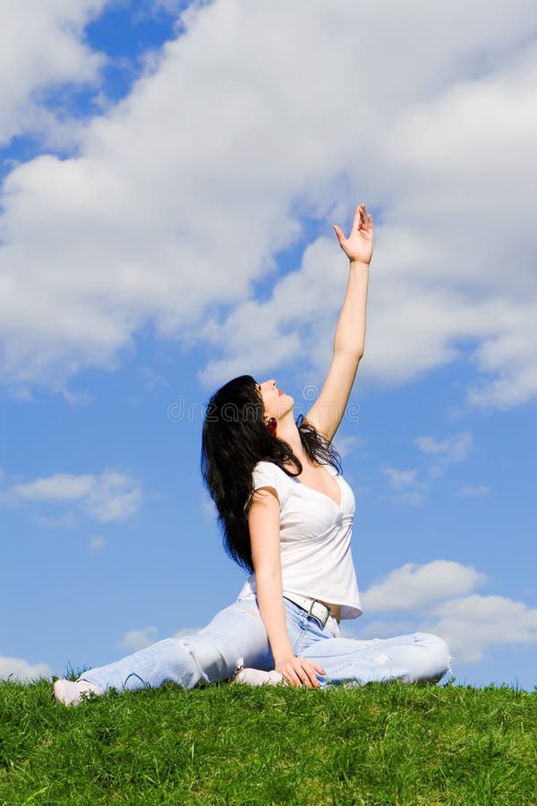 Woman on a green meadow and show something