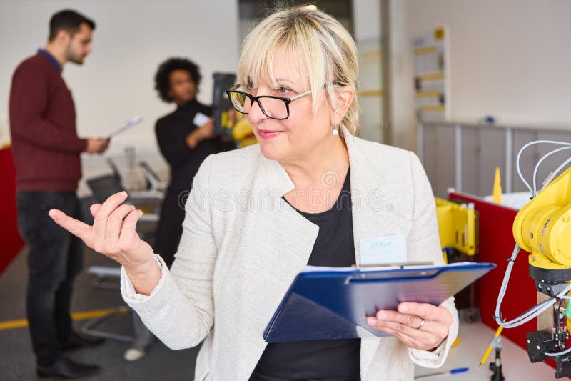 Woman guiding robot programming session in modern office setting stock photo