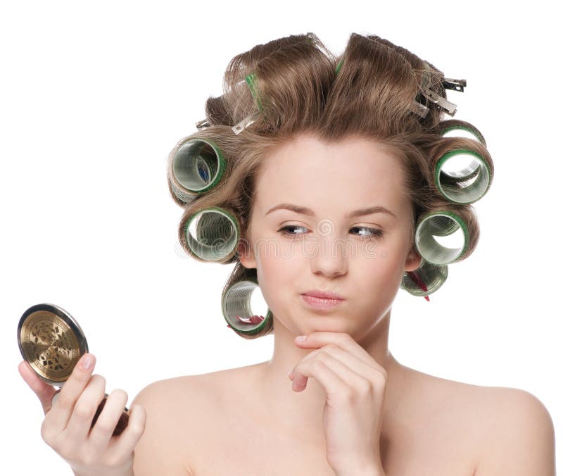 Woman in hair roller looking in mirror