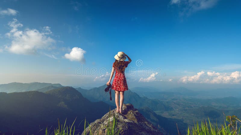 Woman hand holding camera and standing on top of the rock in nature. Travel concept. Vintage tone