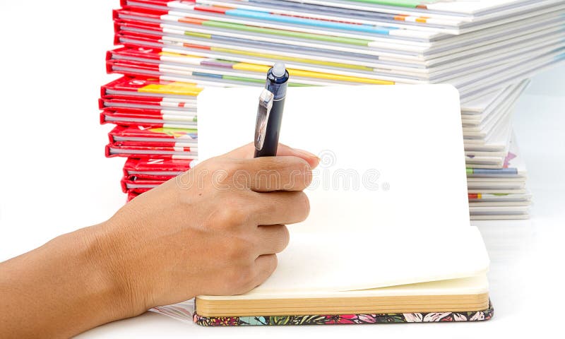 Woman hand holding pen writing on book. royalty free stock images Woman hand holding pen writing on book. royalty free stock images