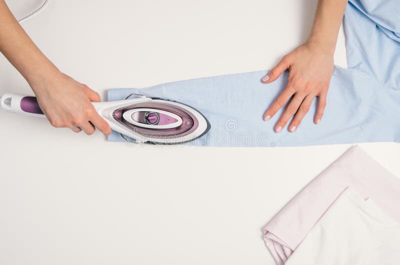 Woman Hand Ironing A Shirt, On Cloth Background Stock Photo