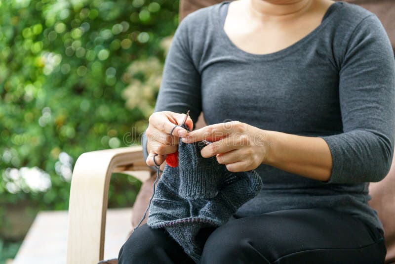 Woman hand knitting in a garden stock image Woman hand knitting in a garden stock image
