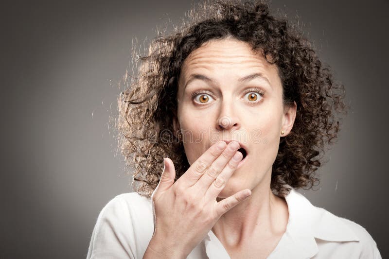 Woman with hand over mouth stock image
