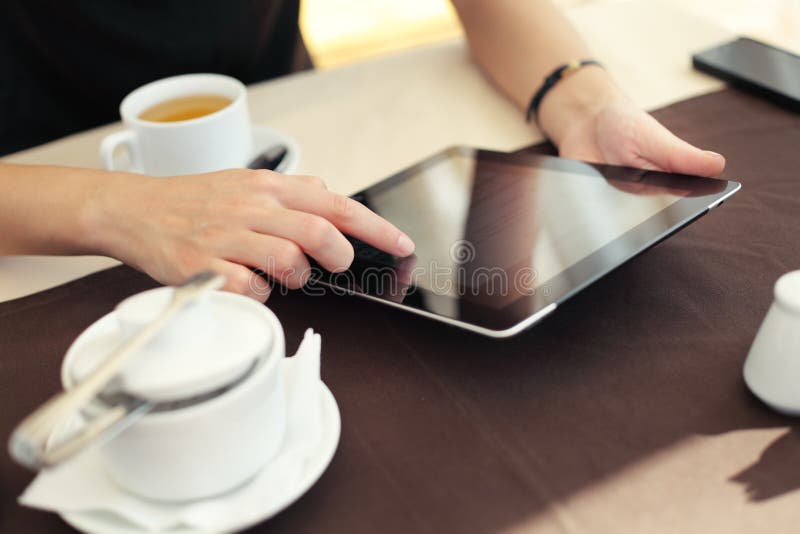 Woman hand pointing at tablet touchscreen in cafe royalty free stock photography