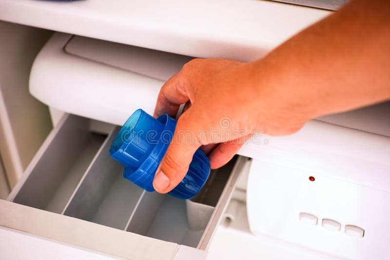 Woman Hand Pouring Liquid Detergent in Washing Machine Stock Photo
