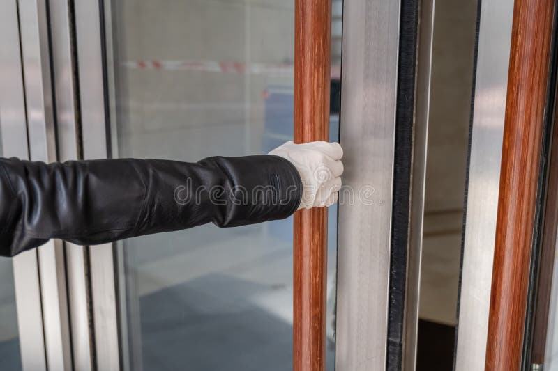 Woman hand in a protective white rubber gloves holds handle and and opening the door. Health protection against viruses, germs and bacteria. Coronavirus epidemic