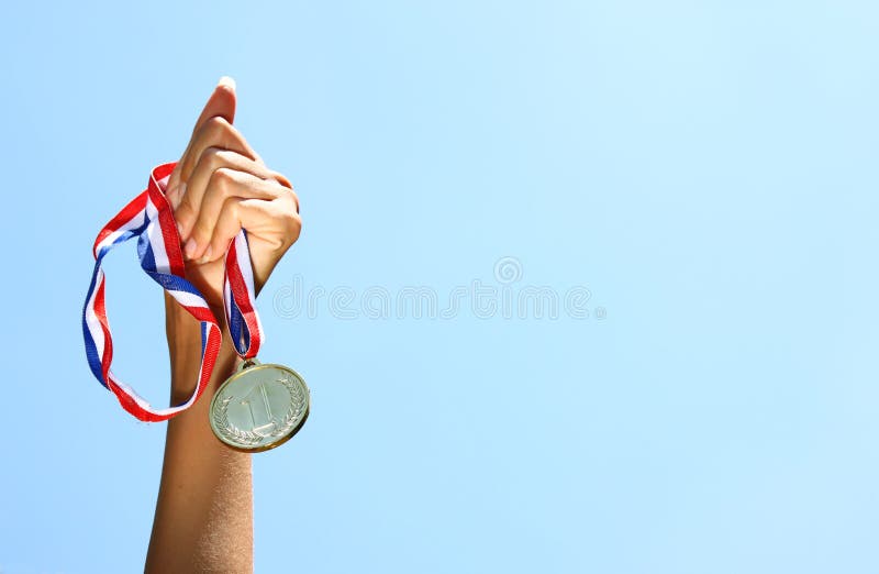 Woman hand raised, holding gold medal against skyl. award and victory concept. selective focus. retro style image.