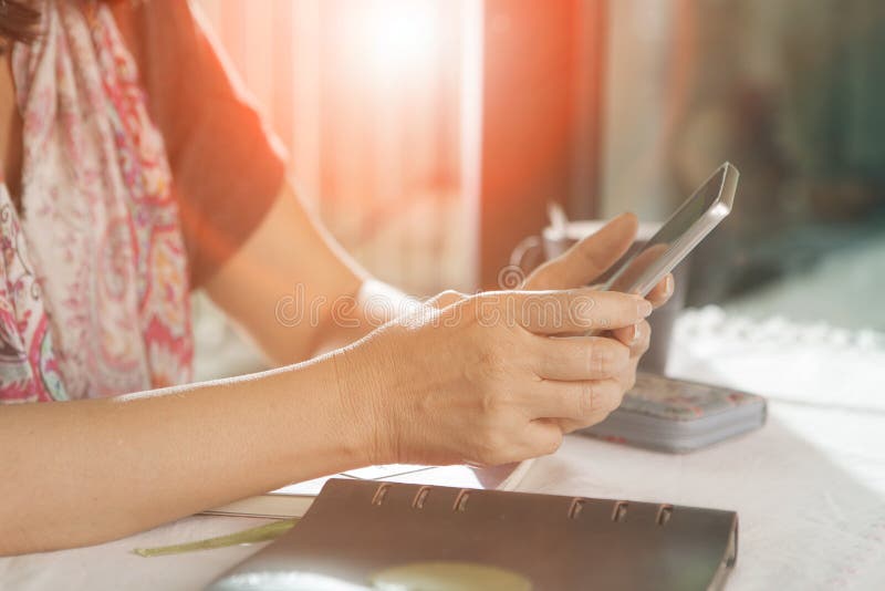 Woman hand sitting on working table and using smartphone ,for pe royalty free stock photos Woman hand sitting on working table and using smartphone ,for pe royalty free stock photos