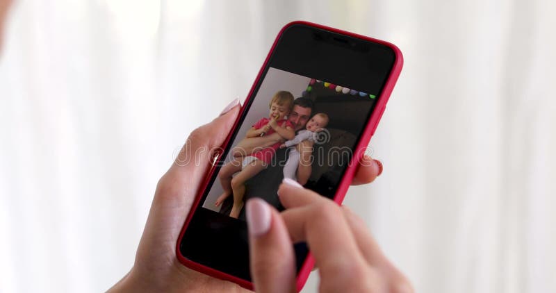 Woman hand with smartphone showing family picture