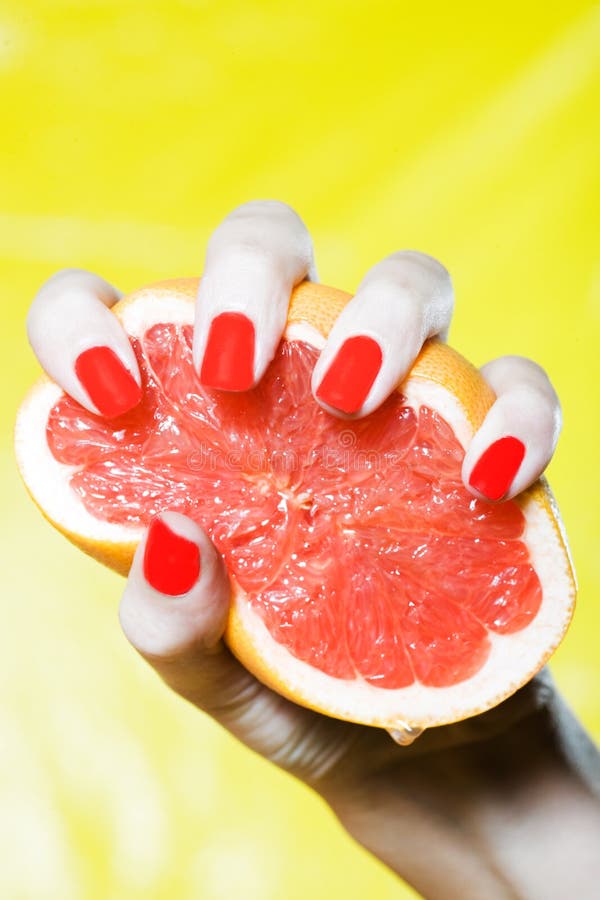 Woman Hand Squeezing a grapefruit