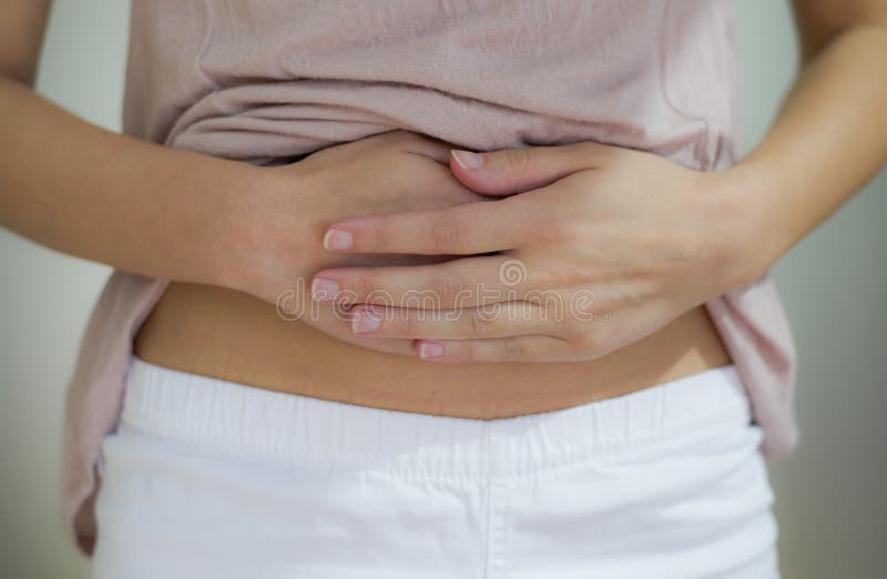 Woman in underwear with her hands on her stomach - Stock Photo