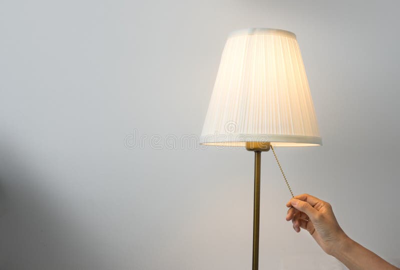 Female hand switch on table lamp