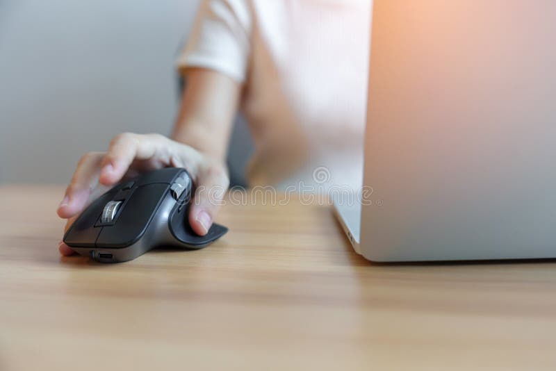 Woman Hand Using Ergonomic Vertical Mouse during Working on Adjustable