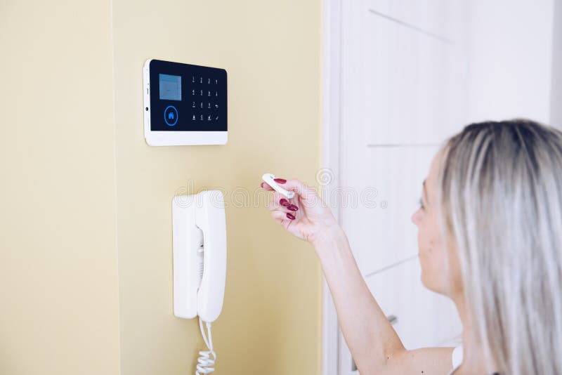 Woman& x27;s hand holding remote controlled home security system. royalty free stock photo
