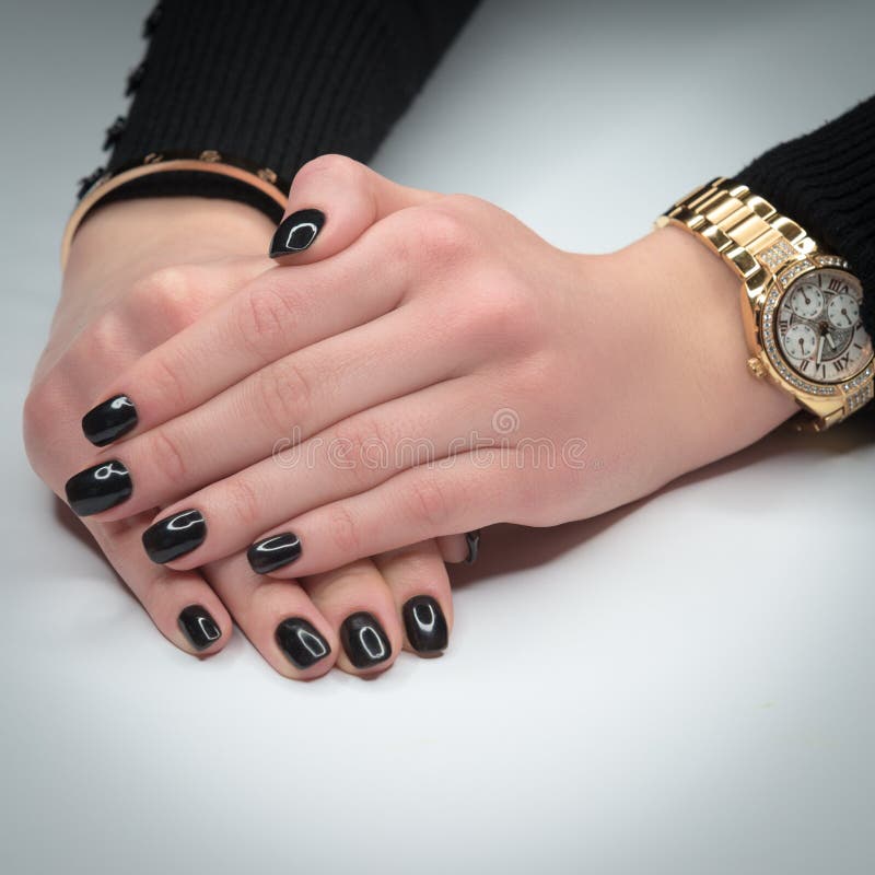 Woman hands with beautiful manicure on white background. On hand a gold bracelet and watch.