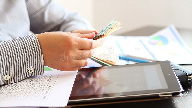Woman hands counting and calculating money on tablet computer
