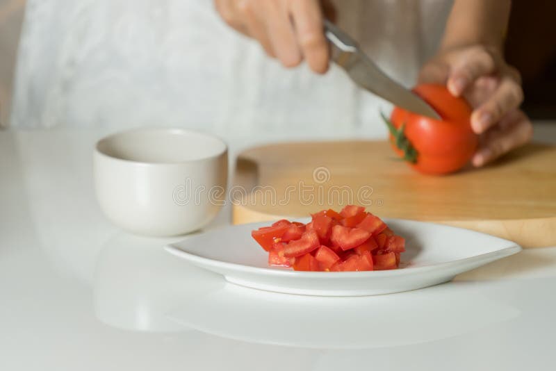 Woman is hands cutting tomato on wood board. stock image Woman is hands cutting tomato on wood board. stock image