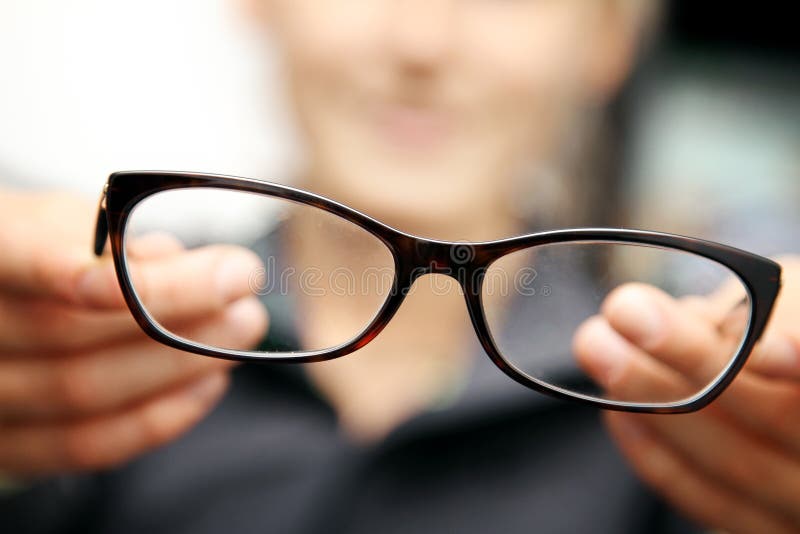 Woman hands hold eyeglasses in front of her