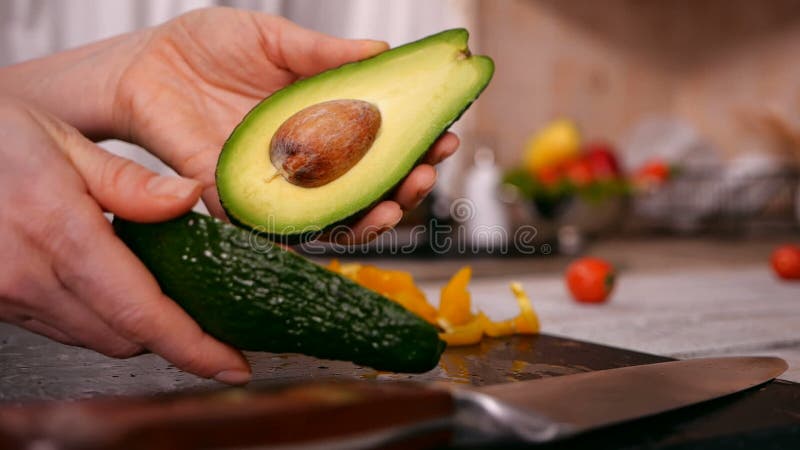Woman hands holding an avocado - separating the two halves stock footage