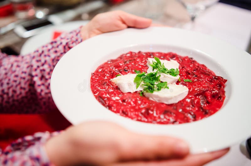 Woman hands holding beetroot risotto