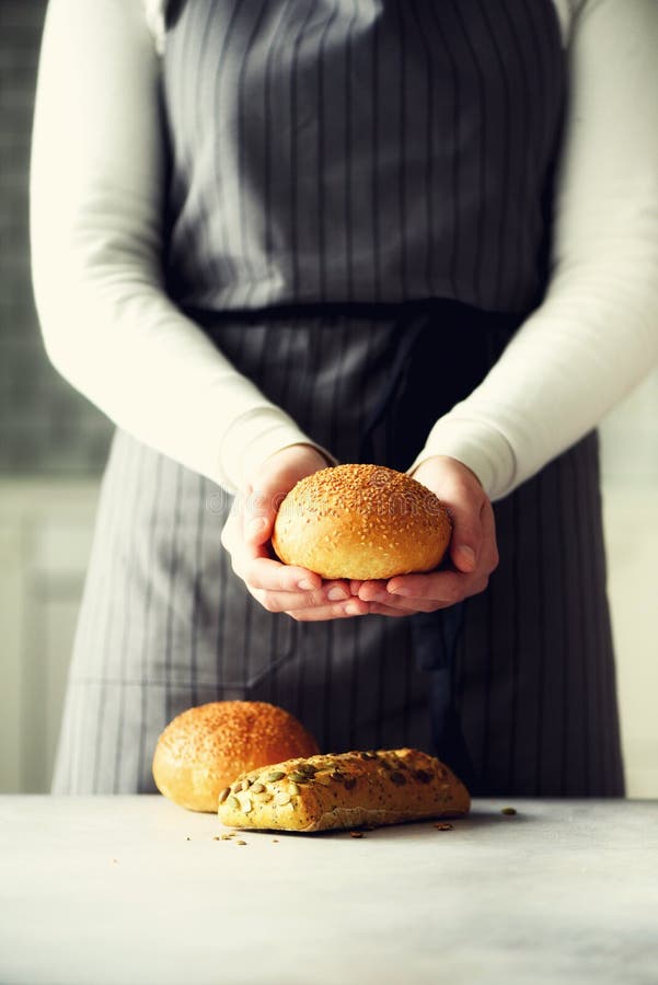 Woman hands holding freshly baked bread. Bun, cookie, bakery concept, homemade food, healthy eating. Copy space. Banner. royalty free stock image Woman hands holding freshly baked bread. Bun, cookie, bakery concept, homemade food, healthy eating. Copy space. Banner. royalty free stock image