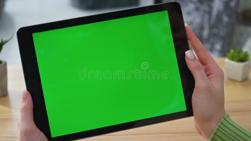 Woman hands holding green screen tablet video in modern home office closeup stock video footage