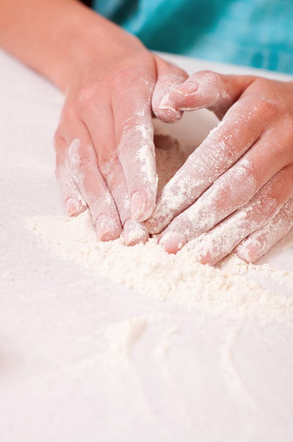 Woman hands mixing flour on the table