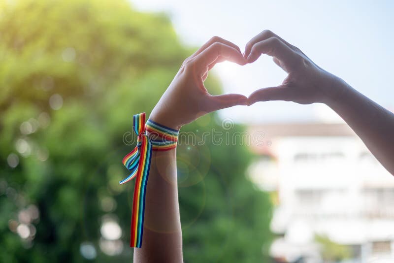 Woman hands showing heart shape sign with LGBTQ Rainbow ribbon in the morning for Lesbian, Gay, Bisexual, Transgender and Queer royalty free stock photos Woman hands showing heart shape sign with LGBTQ Rainbow ribbon in the morning for Lesbian, Gay, Bisexual, Transgender and Queer royalty free stock photos