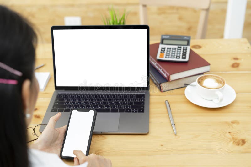 Woman hands using white screen smartphone and laptop mockup royalty free stock photo Woman hands using white screen smartphone and laptop mockup royalty free stock photo