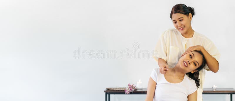 Masseuse massages the neck & shoulders of a woman - Stock Image