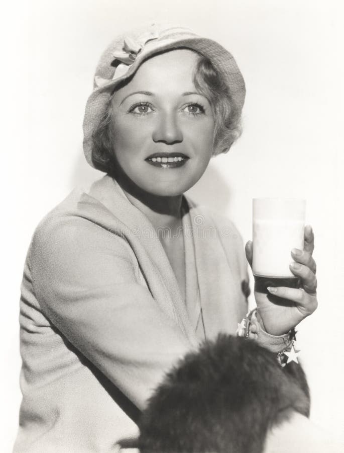 Woman in hat holding a glass of milk