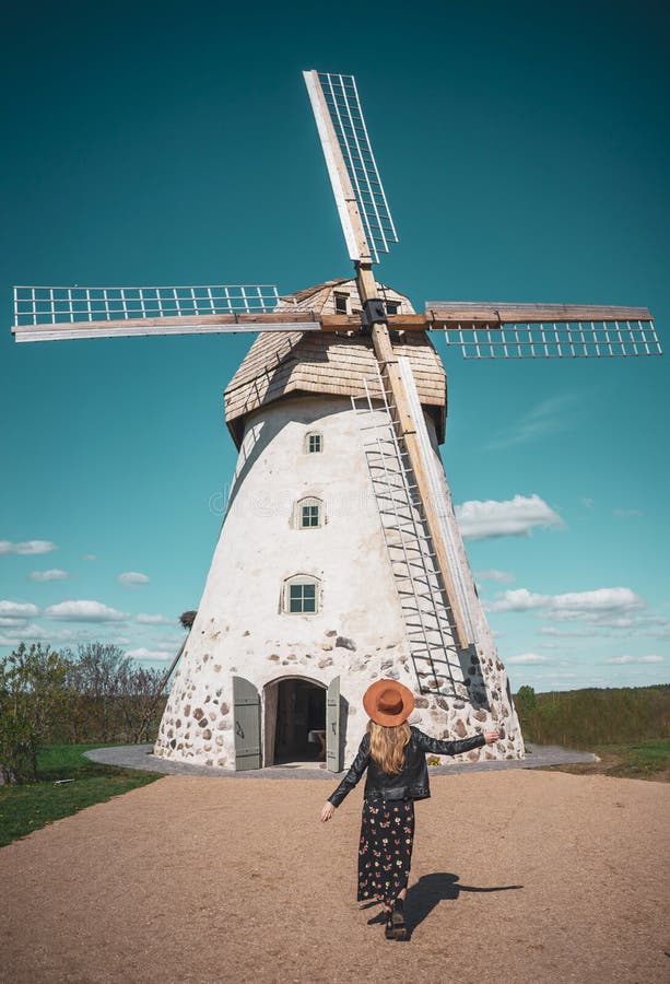Woman in hat looking at old wildmill building, summer sunny day stock photography Woman in hat looking at old wildmill building, summer sunny day stock photography