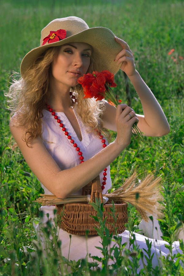 Woman in hat with poppy bouquet